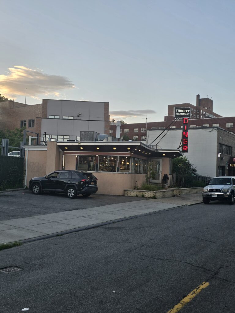 Tibbett Diner exterior at dusk with parked cars, Bronx NY