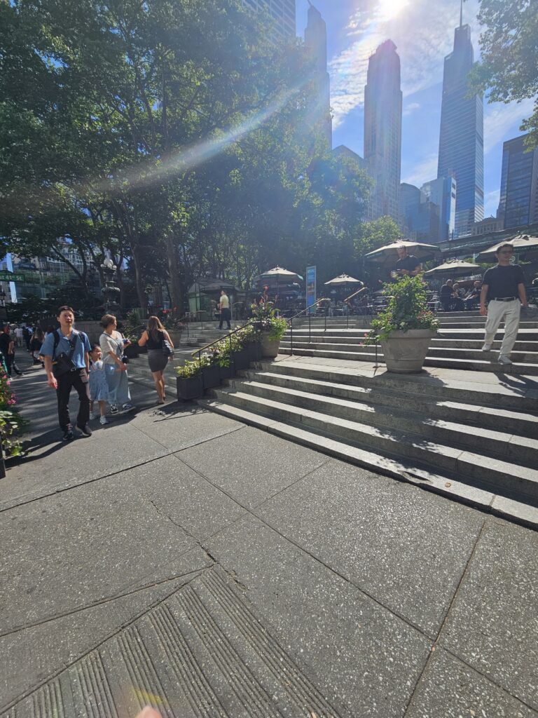 Bryant Park NYC main entrance stairs with Manhattan skyscrapers in background