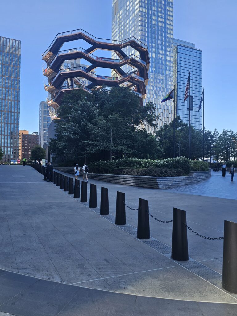 Wide-angle view of The Vessel Hudson Yards with bollards and landscaping in foreground