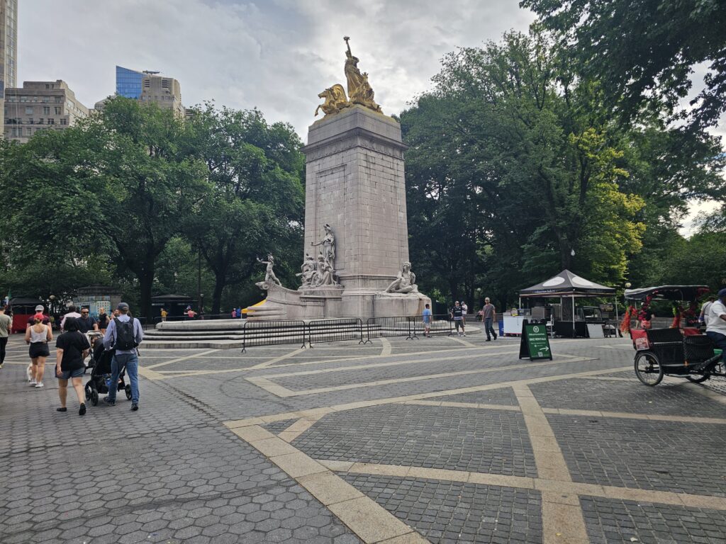 Visitors walking around the USS Maine National Monument at Columbus Circle Central Park entrance