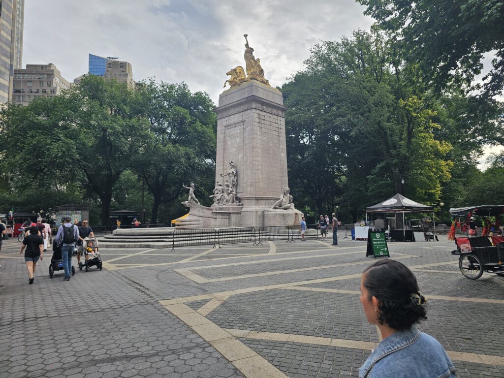 USS Maine National Monument from the side showing gilded bronze figure and Columbus Circle NYC