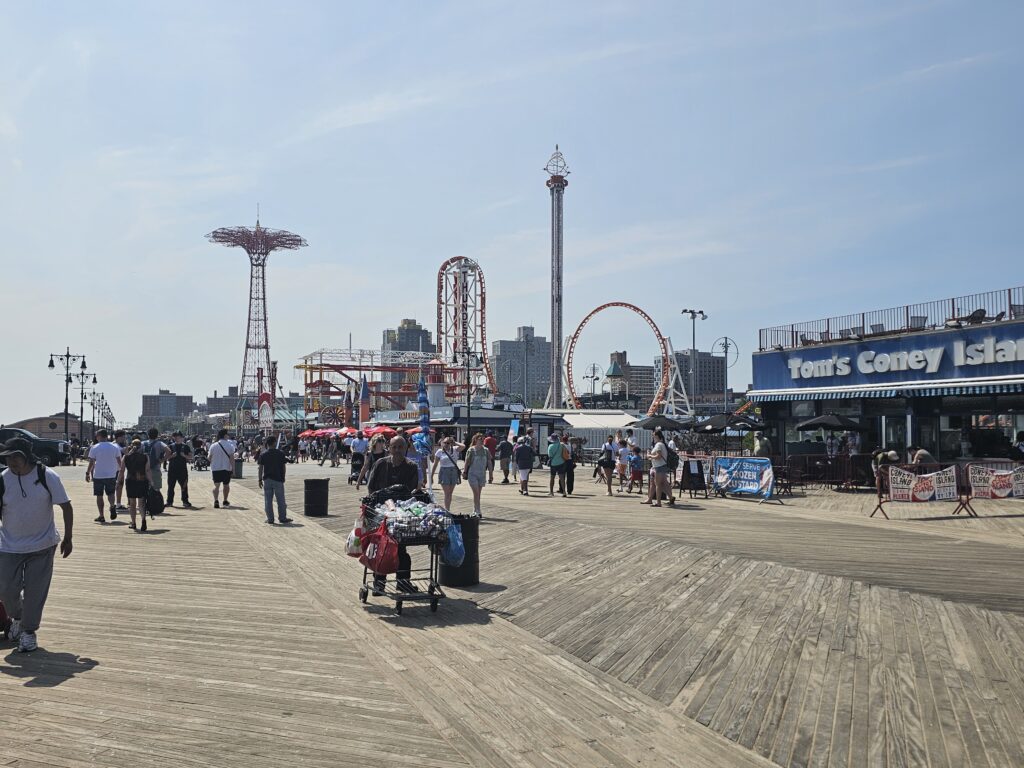 Coney Island NYC guide: boardwalk pathway with amusement rides