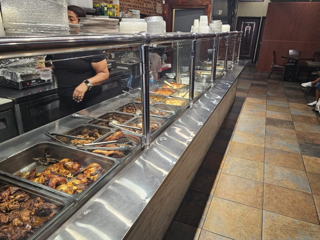 Buffet-style food display counter at 809 Bar & Grill Dominican restaurant