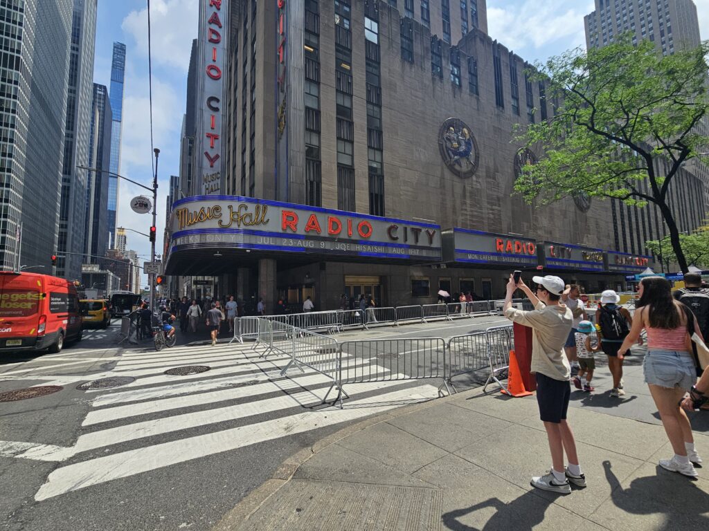 small/caption size — caption: "Visitors photographing the marquee on Sixth Avenue