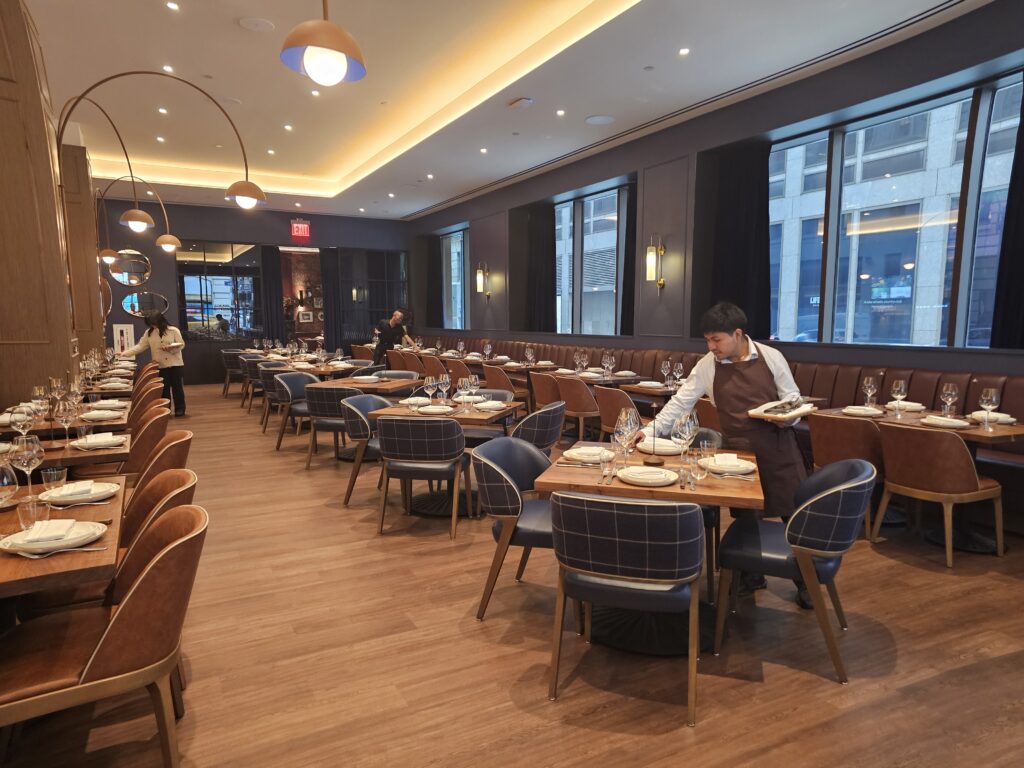 Server at Tallow Steakhouse dining room Shaver Hall food hall NYC
