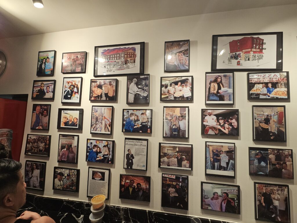 Joe's Pizza Midtown Wall of Fame covered in celebrity and press photos