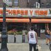 : Cachapas y Mas NYC storefront sign with orange and green awning in Inwood, Manhattan