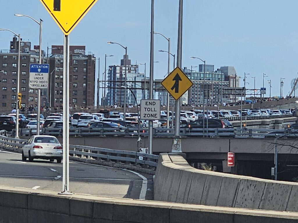 Traffic and END TOLL ZONE sign on the Brooklyn Bridge roadway
