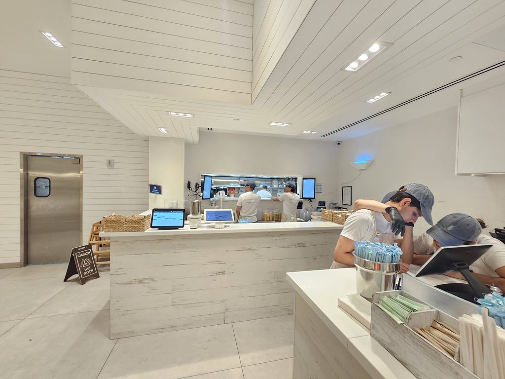 Staff preparing fresh food behind the open counter at Pura Vida Miami NYC