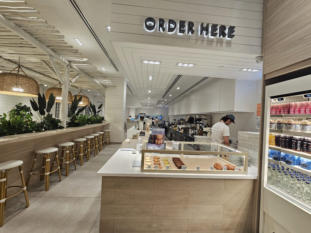 Order Here" counter and pastry case at a Pura Vida Miami NYC location