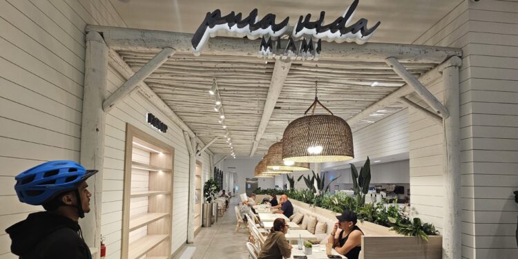 Pura Vida Miami NYC storefront sign glowing above the dining room entrance