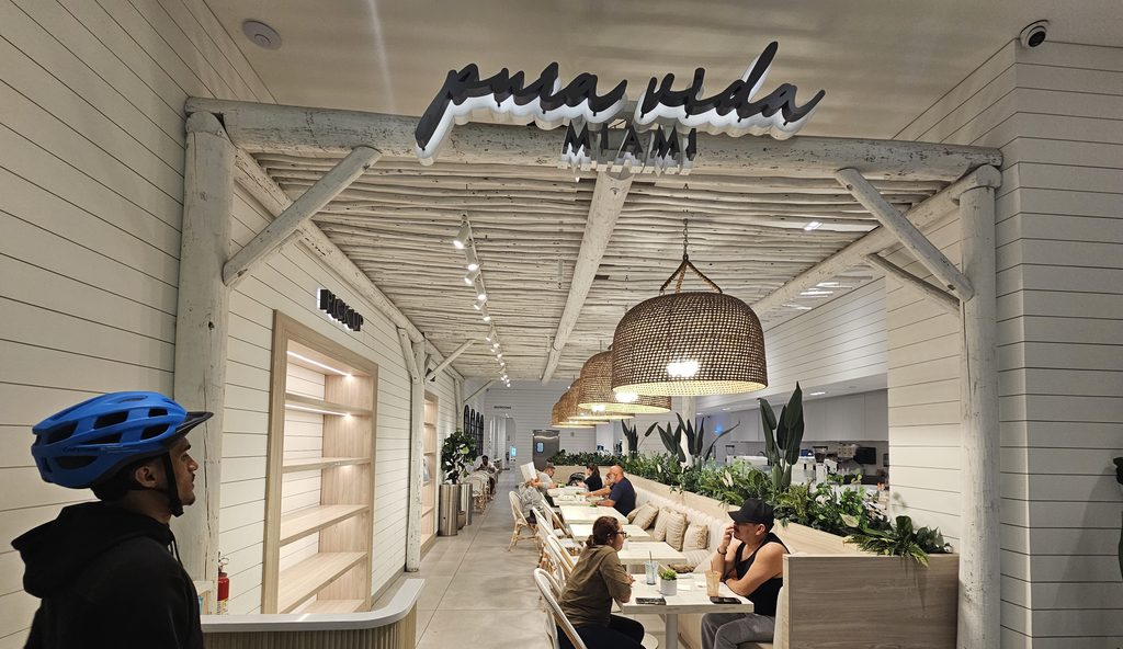 Pura Vida Miami NYC storefront sign glowing above the dining room entrance
