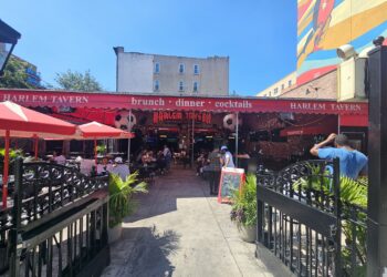Harlem Tavern NYC entrance patio with red awnings and outdoor seating
