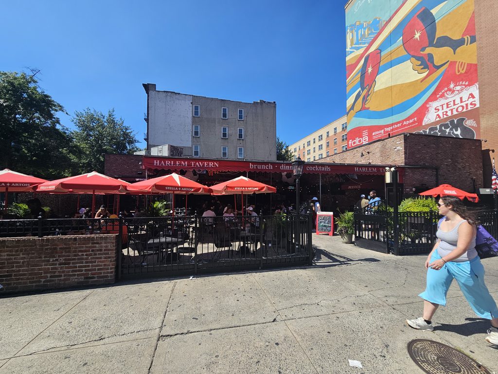 Harlem Tavern NYC entrance patio with red awnings and outdoor seating