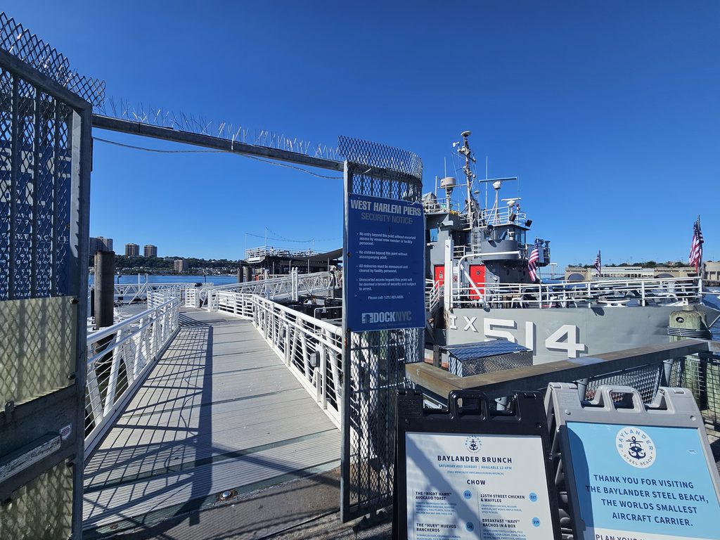 Gated entrance to West Harlem Piers with Baylander Steel Beach visible on the dock
