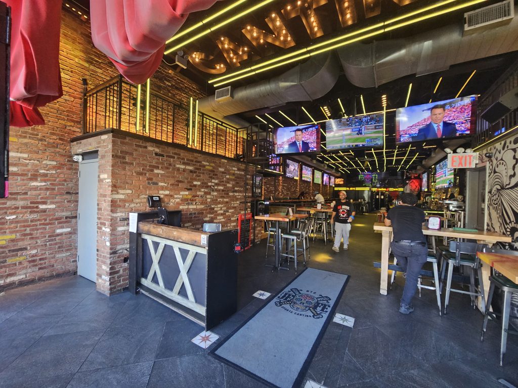 Host stand at El Jefe Sports Cantina beneath a glowing CANTINA neon sign