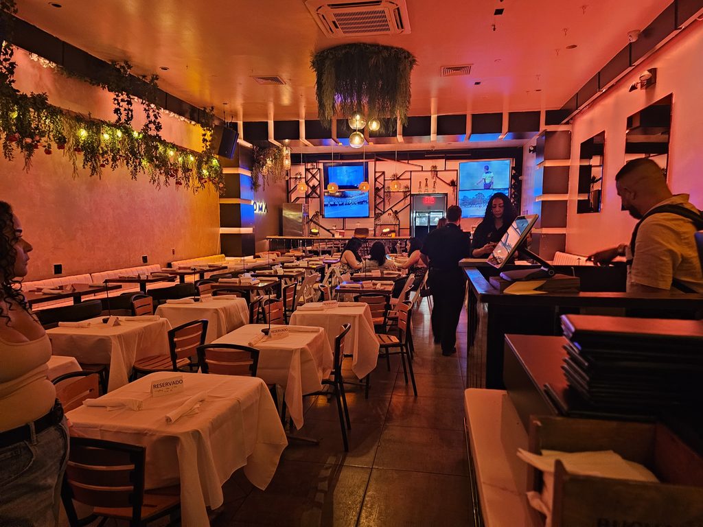 Aroma Restaurant Bar dining room with candlelit tables and hanging greenery