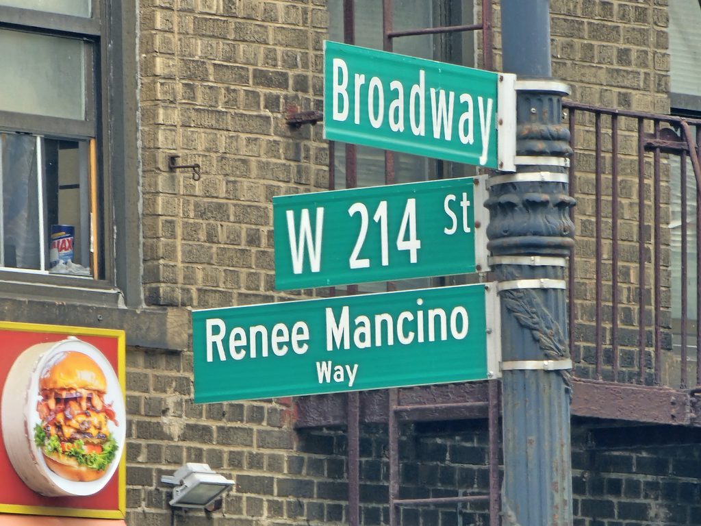 Broadway and West 214th Street sign near Portes Cigars in Inwood