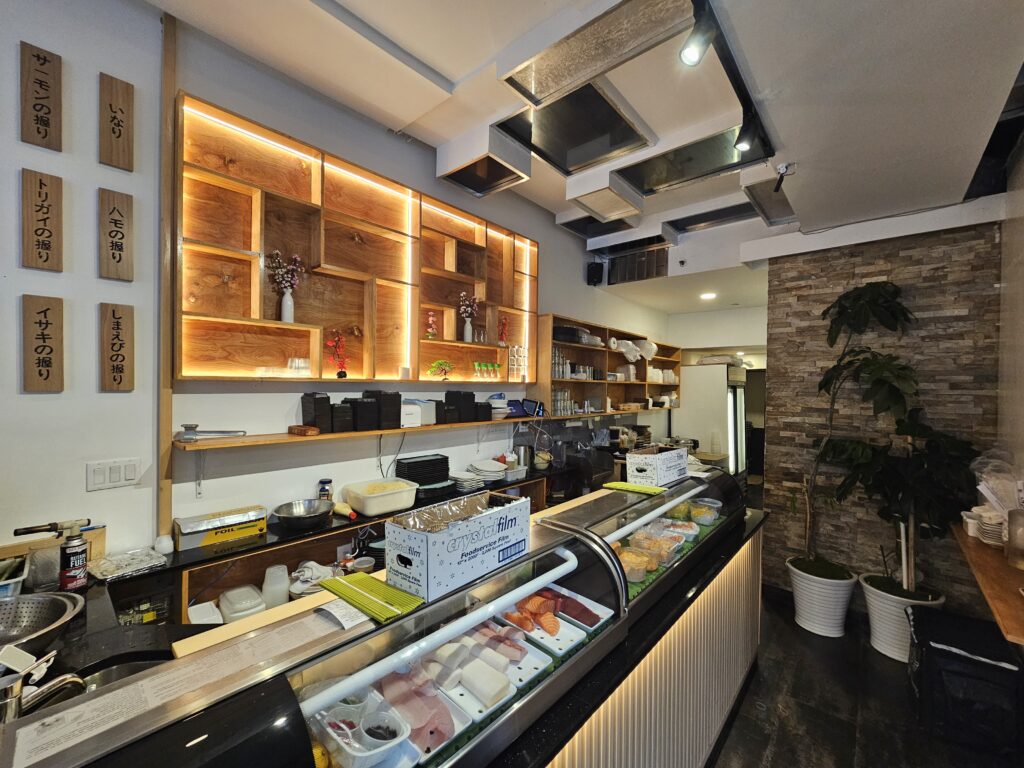 Fresh sushi and sashimi display case at Junko Sushi Astoria