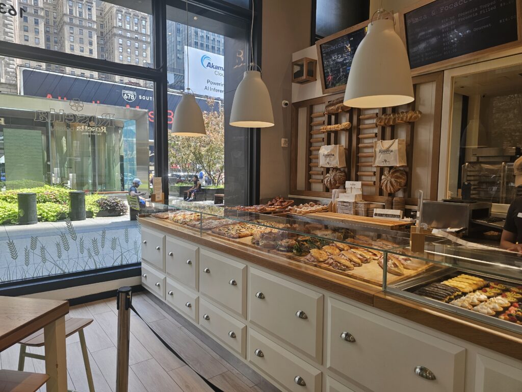 Rosetta Bakery bread and pastry display with Bryant Park visible through the window