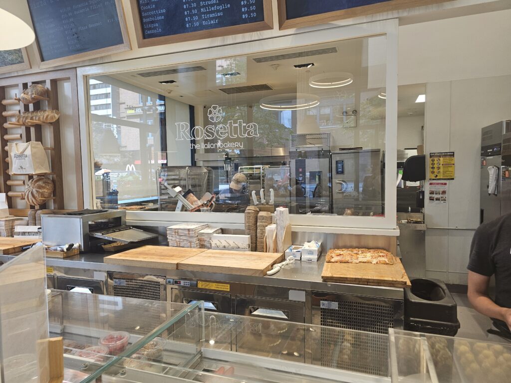 Rosetta Bakery open kitchen with fresh pizza and bakers at work