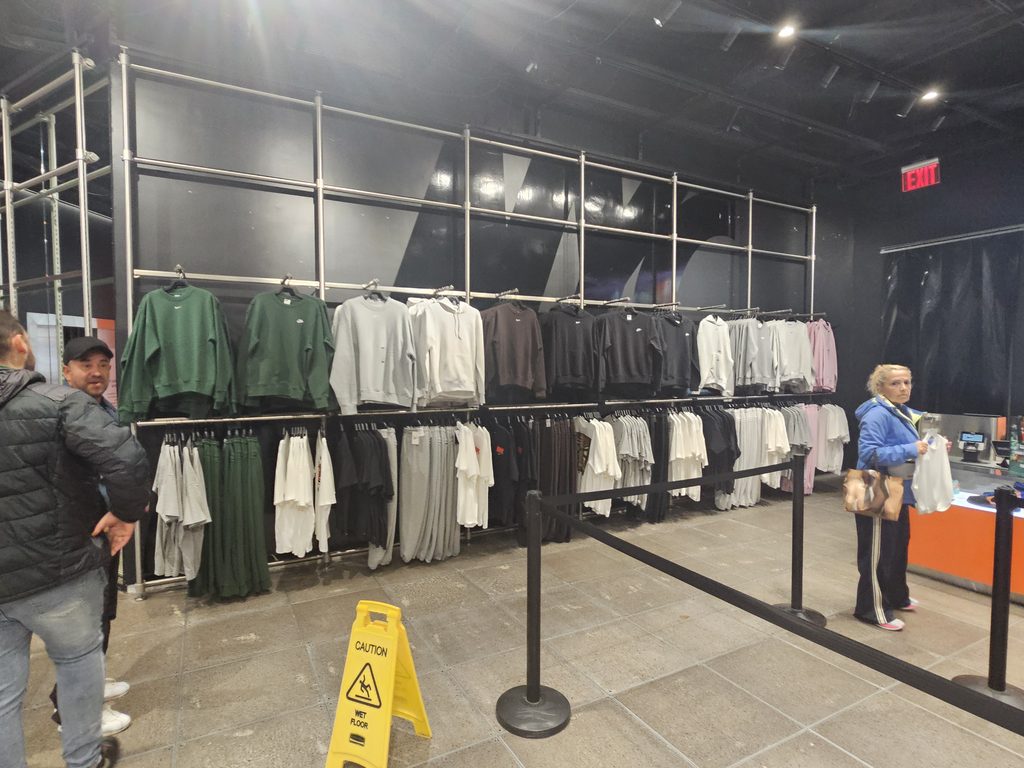 Racks of Nike sweatshirts, hoodies, and pants on a lower level of the flagship store