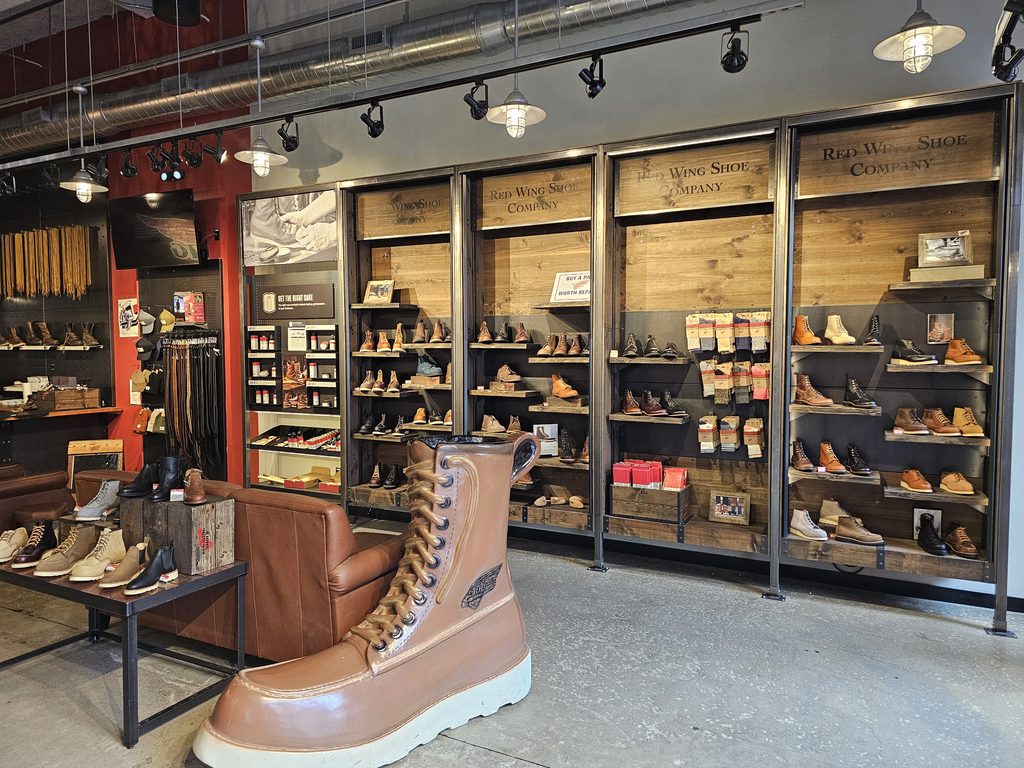 Giant Red Wing boot display beside wall of boots at Red Wing Shoes NYC in Manhattan