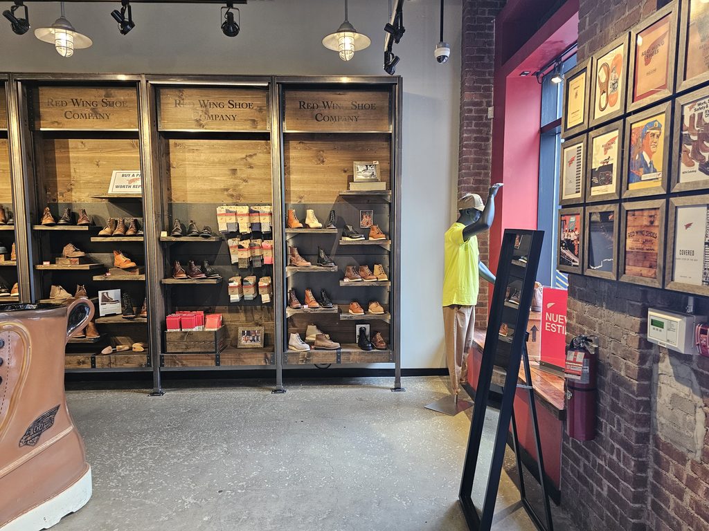 Wooden boot shelves and framed vintage prints inside Red Wing Shoes NYC flagship store