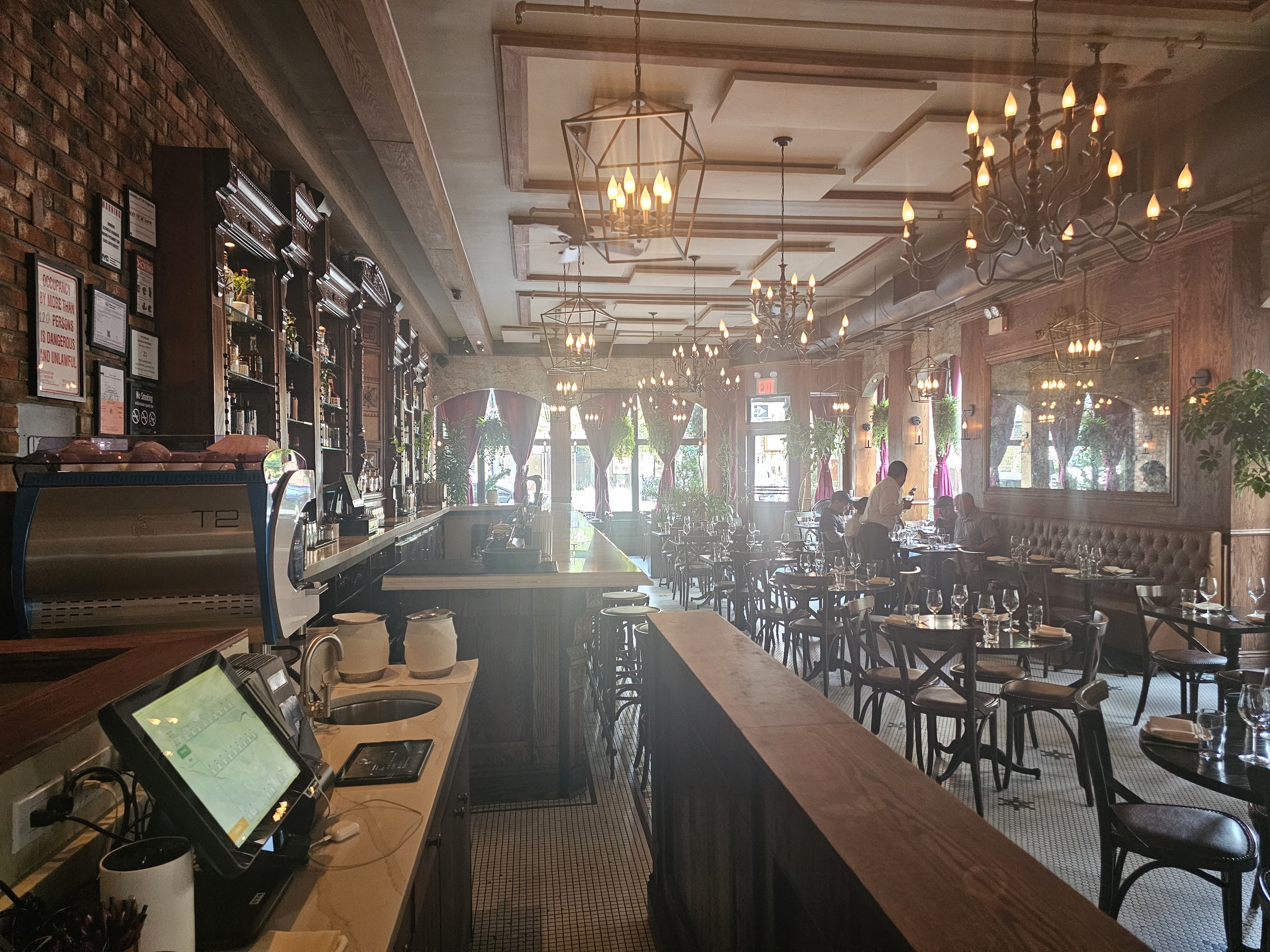 Warm wood, mirrors, and chandelier lighting shape the main dining room.