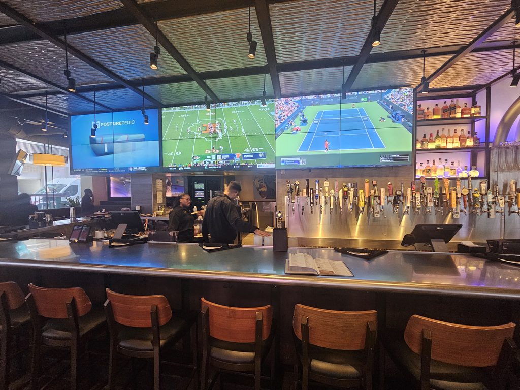 Yard House NYC bar area with draft taps and sports screens