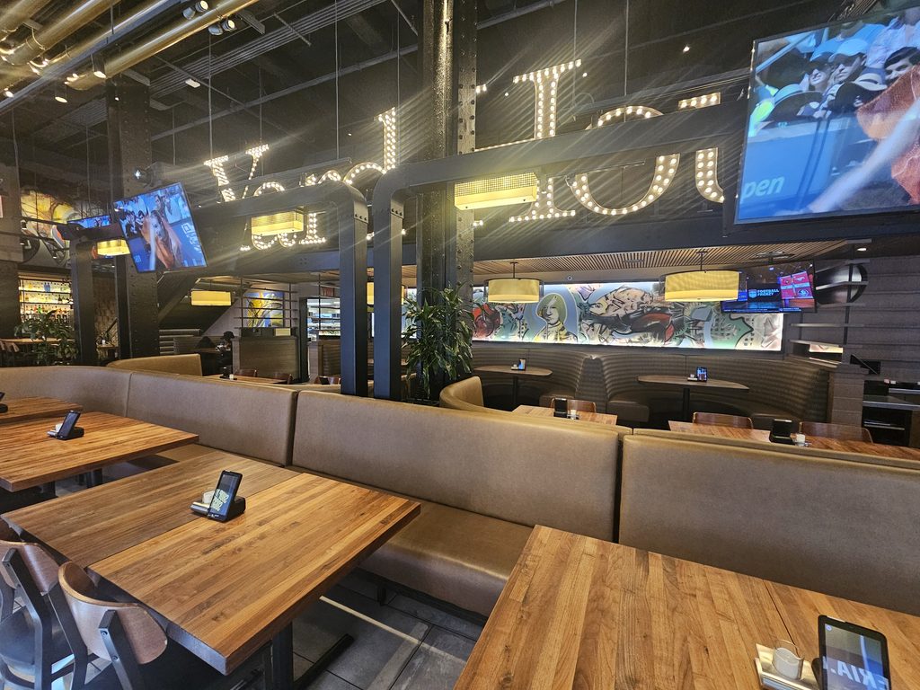 Yard House NYC dining room with classic-rock screens and booth seating