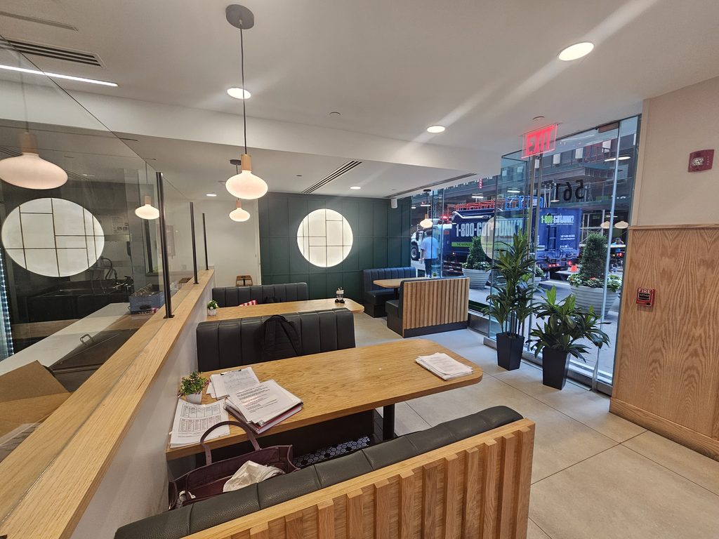 Seating area inside Wasabi Sushi & Bento Times Square near the 7th Avenue windows