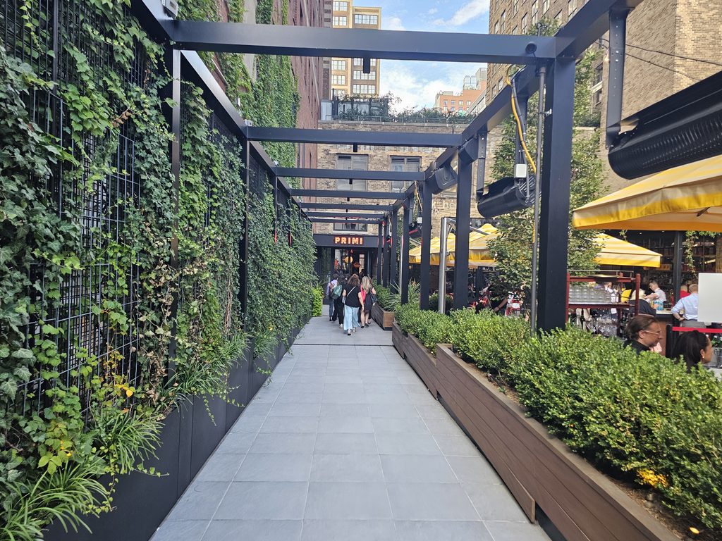 Bar Primi Penn District outdoor patio with yellow umbrellas and diners