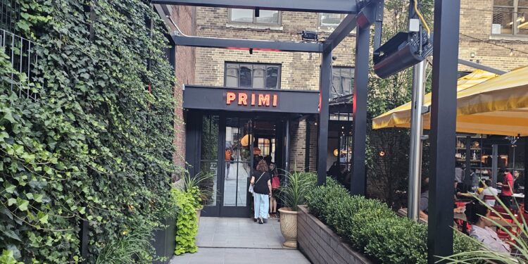 Bar Primi Penn District exterior with PRIMI sign and Midtown buildings