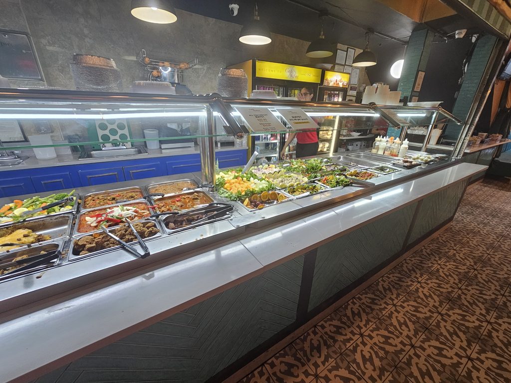 Café Nuñez NYC buffet counter displaying a wide selection of prepared dishes