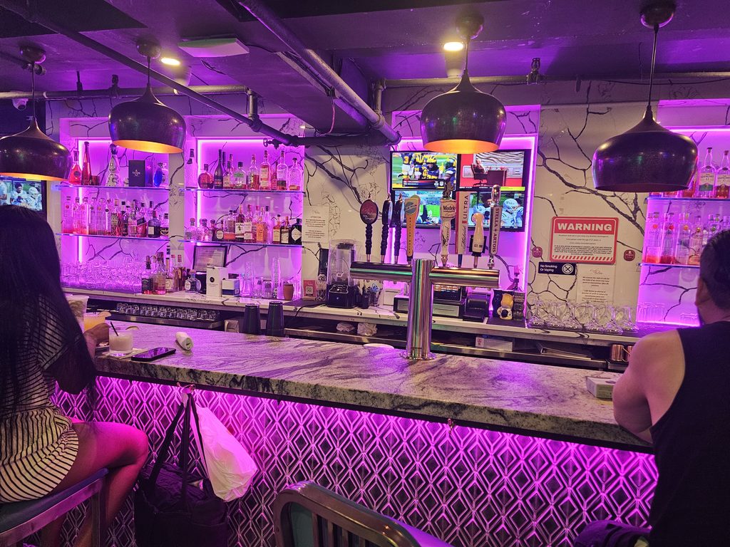 Café Nuñez NYC lounge bar illuminated with purple lighting at night