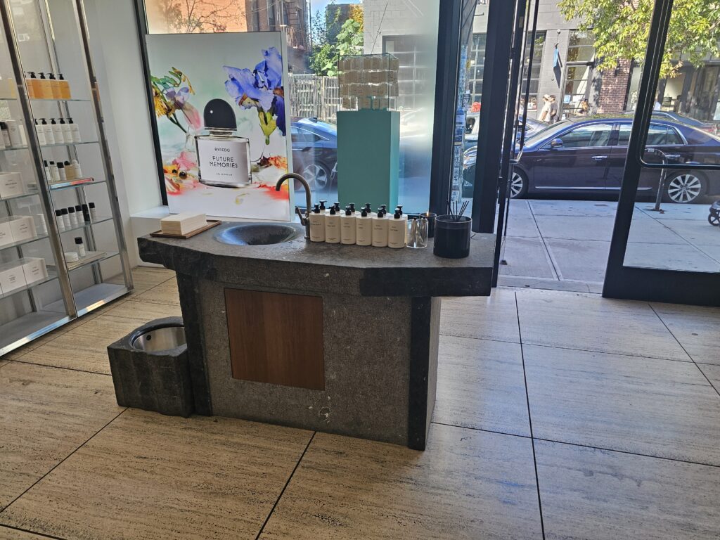 BYREDO Williamsburg interior with stone sink, fragrance products, and street-facing windows