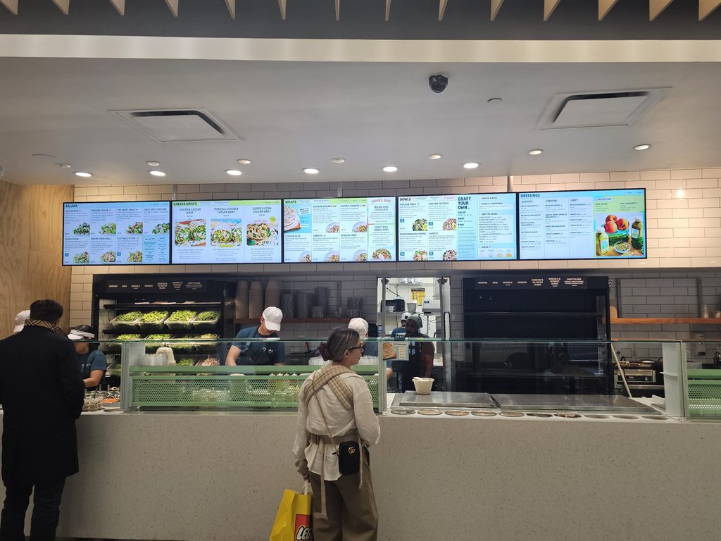 Digital menu screens above the counter at Chopt Midtown Manhattan