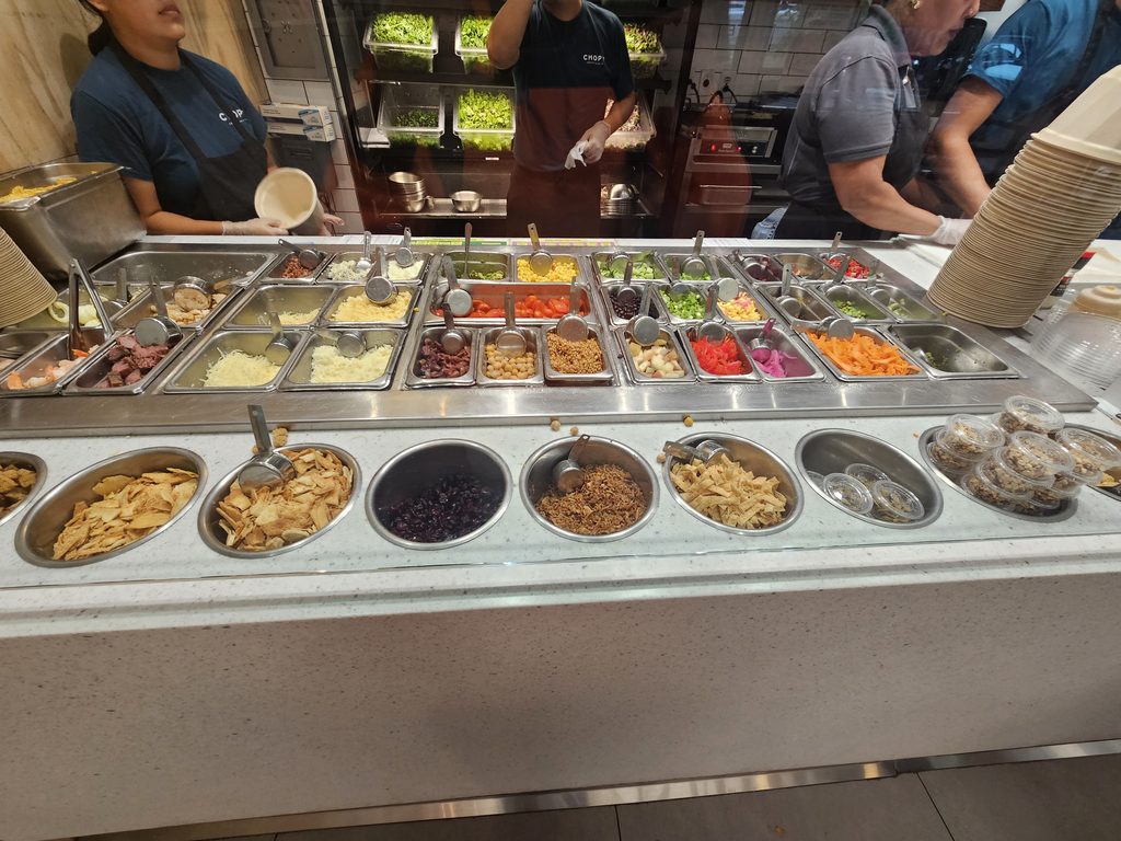 Topping bar and prep crew chopping salads at Chopt Midtown Manhattan